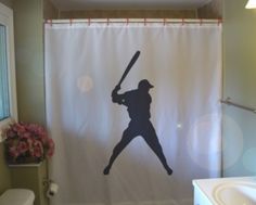 a bathroom with a shower curtain that has a silhouette of a baseball player holding a bat