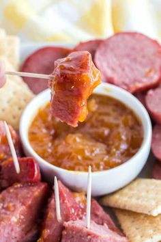 hot dogs and crackers on a plate with dipping sauce