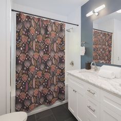 a bathroom with a shower, sink and toilet covered in floral wallpaper next to a bathtub