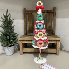 a christmas tree made out of doughnuts sitting on top of a wooden bench