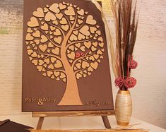 a wooden sign with hearts on it next to some dried flowers and a vase filled with dry grass