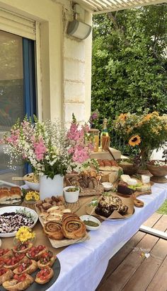 a table full of food sitting on top of a wooden floor next to a window