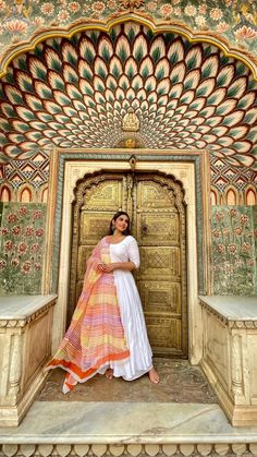 a woman standing in front of an ornate doorway