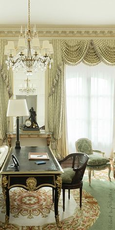 an elegant living room with chandelier and chairs