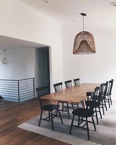 a dining room table with black chairs and an area rug