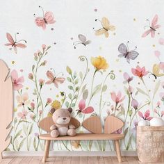 a teddy bear sitting on a bench in front of a wall with flowers and butterflies