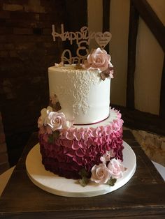 a white and pink cake with flowers on top