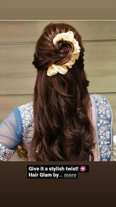 a woman with long brown hair wearing a flower in her hair