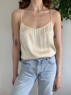 Vintage Diane Von Furstenberg satin camisole top. Fabric is an ivory color that has a slight stretch.  Brand / Diane Von Furstenberg Size / Marked 10 (fits like a women's small) Material / 60% polyamide, 40% viscose Condition / Excellent - one small stain (pictured) Measurements (taken flat, double where appropriate): Strap: 7.5 in Pit to pit: 16 in Waist: 15.75 in Hem: 17 in Total length: 13.5 in Feel free to message me with any additional questions! Cream Tank Camisole For Spring, Beige Satin Tops For Spring, Vintage Satin Tops For Spring, Vintage Spaghetti Strap Camisole For Spring, Cream Fitted Top With Spaghetti Straps, Cream Fitted Spaghetti Strap Top, Vintage Spring Camisole With Spaghetti Straps, Vintage Spring Camisole, Sleeveless Cream Silk Top