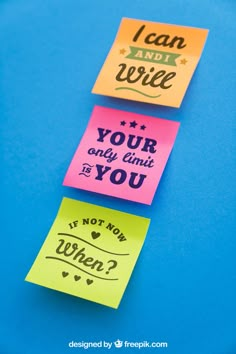 three different colored sticky notes on a blue surface