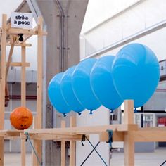 several blue balloons are tied to wooden poles