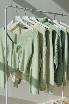 several sweaters are hanging on a clothes rack