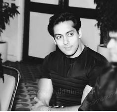 a black and white photo of a man sitting at a table