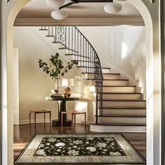 an entry way with a rug, table and stairs