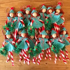 a group of christmas elves with candy canes on a wooden table next to other decorations