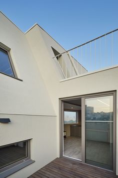 an open patio with sliding glass doors leading to the roof deck and balcony area that overlooks the ocean