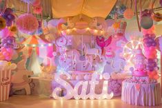 an elaborately decorated stage with balloons, lights and decorations for a children's birthday party