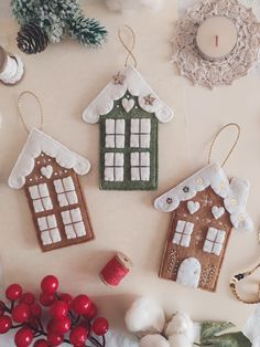 three gingerbread house ornaments on a table