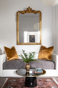 a living room filled with furniture and a large mirror above the coffee table in front of it