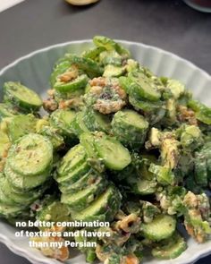 a white bowl filled with cucumbers on top of a table