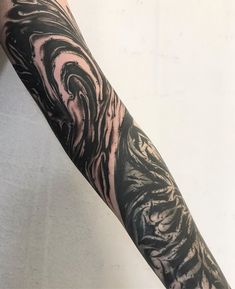 a man's arm with black and white swirls on the side of it