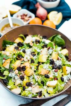 a salad with apples, raisins and cheese in a bowl on a table