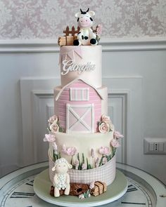 a pink and white cake with farm animals on top