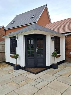 a small white building with black doors and windows