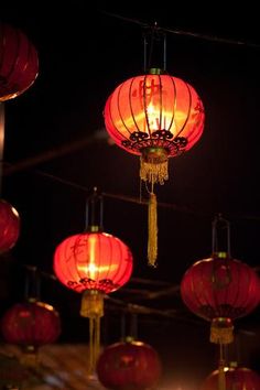 red lanterns hanging from strings in the dark