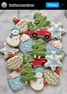 decorated christmas cookies with snowmen, trees and cars in them on a marble surface