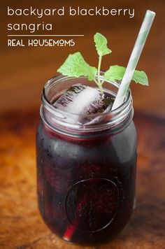 a jar filled with liquid sitting on top of a wooden table next to a green leaf