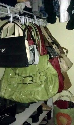 a purse is hanging on a rack with shoes and other items in the closet next to it