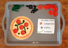 a tray that has some pizza on it and buttons in the shape of tomatoes, black olives, and pepperoni