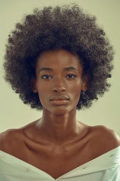 a woman with an afro is looking at the camera