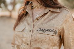 A Western essential with a Rodeo Quincy twist, this golden button-up shines in bronze gold and is finished with beautiful shell buttons. The "Don’t Gild the Lily" embroidery adds a playful nod to the collection’s namesake—sure, less can be more, but a little extra embellishing never hurt anyone. Perfect for cowgirls of all ages, this shirt blends vintage Western charm with a modern edge. *Due to high volume of orders, expect delays in shipping* "Don't Gild the Lily" Embroidery True to Size Butto Gold Long Sleeve Tops With Buttons, Gold Party Tops With Buttons, Chic Gold Tops With Button Closure, Chic Gold Top With Button Closure, Chic Gold Button-up Top, Gold Party Top With Button Closure, Gold Party Tops With Button Closure, Gold Tops With Button Closure For Party, Gold Fitted Button-up Tops