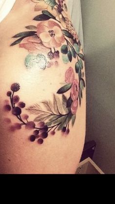 a woman's stomach with flowers and leaves painted on the side of her body