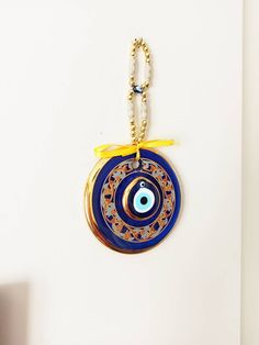 ⭐️Diameter of the blue evil eye bead is 14 cm(5.5 in) ⭐️Height of the blue eye wall charm is 28 cm(11 in) ⭐️Evil eye hanging is gold plated. There are two blue glass beads on the hanging. ⭐️Evil eye bead is painted. ⭐️ Evil Eye is totally handmade. ⭐️The evil eye bead is large and it is perfect for home decoration. ⭐️Turkish eye decor is also gold plated. It is believed that evil eye charm protects you from the evil eyes. Evil eye charm is over 5000 years old. It is found in all major religions Handmade Bohemian Blue Evil Eye Bracelet, Handmade Blue Evil Eye Bracelet For Festival, Handmade Blue Bohemian Evil Eye Bracelet, Bohemian Blue Evil Eye Bracelet For Festival, Handmade Blue Evil Eye Bracelet For Good Luck, Blue Evil Eye Bracelet With Round Beads For Festivals, Blue Evil Eye Bracelet For Festivals, Traditional Blue Evil Eye Jewelry, Handmade Blue Jewelry For Blessing