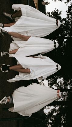 four women in white dresses standing next to each other