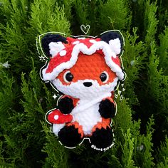 an ornament shaped like a little fox on top of some green plants and trees