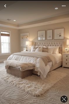 a large white bed sitting in a bedroom next to two lamps on either side of the bed