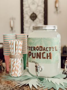 there is a jar with paper straws in it and some cups next to it