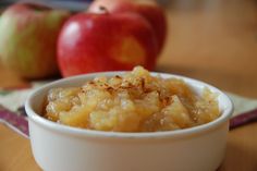 an apple crisp in a white bowl next to apples