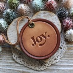 a leather ornament with the word joy on it