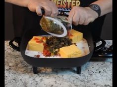 a person is pouring something into a plate with cheese and other food items on it