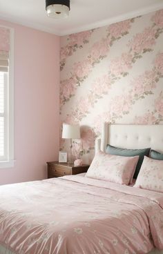 a bedroom with pink walls and floral wallpaper