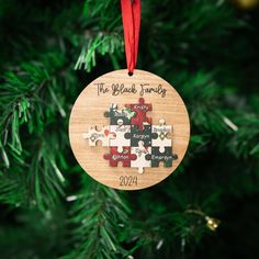 a wooden ornament hanging from a christmas tree with puzzle pieces on it's side