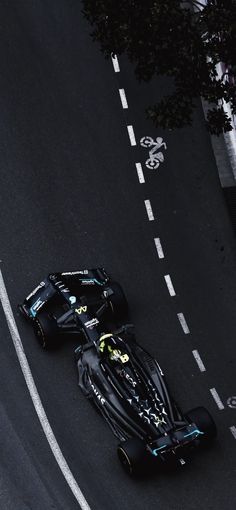 two racing cars driving down the road next to each other