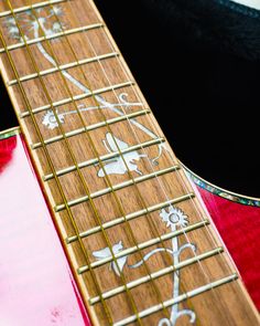 a close up of the frets on an electric guitar with flowers painted on it