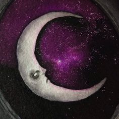 a purple moon sitting on top of a black plate