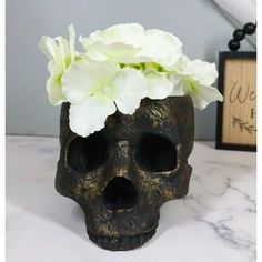 a skull vase with white flowers in it